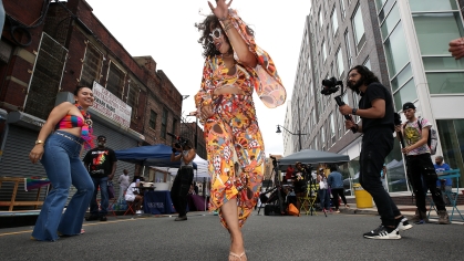 woman dancing on city street followed by camera crew