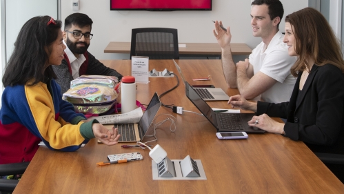 students discussing around meeting table