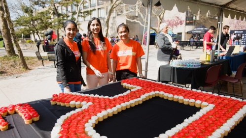 Students standing in back of table with cupcakes