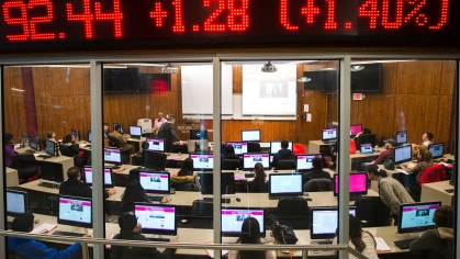 stock ticker above students in computer lab
