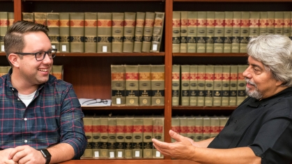 two men speaking in library