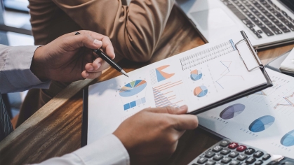 hand gesturing at accounting graphs with a pen