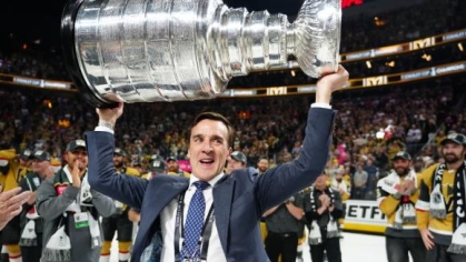 george mcphee triumphantly holding the stanley cup above his head