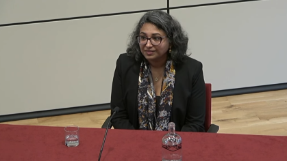 gaiutra bahadur sitting at podium