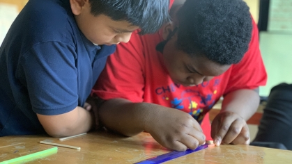 2 children using a ruler to measure things