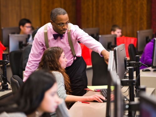 professor gesturing at student's computer monitor