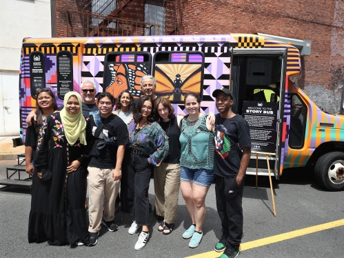 group of students in front of the story bus