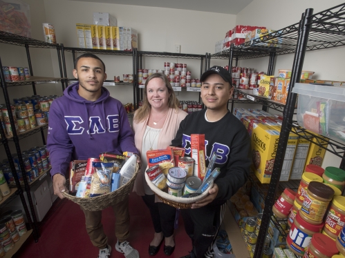 volunteers in food pantry holding baskets of food