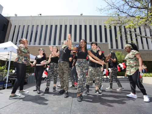 group of students in black and camo-print uniforms dancing