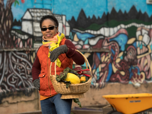 warmly-dressed woman holding a basket of fruit