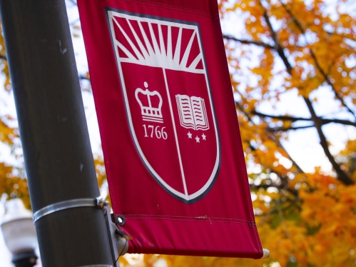 rutgers shield flag on a pole outside