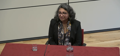 gaiutra bahadur sitting at podium